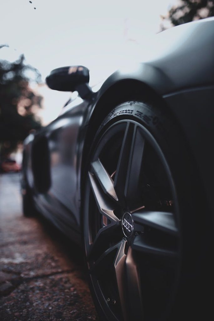 Close-up shot of a sleek, modern luxury sports car wheel with focus on design and details.